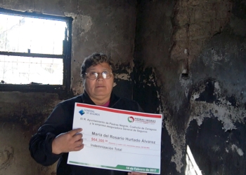 Entregan cheque del seguro contra daños a mujer que perdió su casa