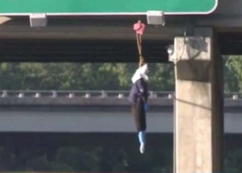 Aparece maniquí vestido de policía con cartel del KKK colgado de puente en Florida