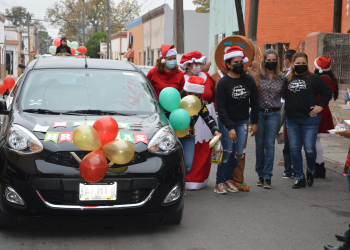 Entrega Norma Treviño bolsas de dulces a estudiantes en desfile navideño