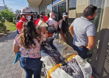 En camilla, abuela acude al banco para poder tramitar su tarjeta para el pago de la pensión