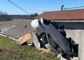 Cadillac se vuelca y choca contra vivienda